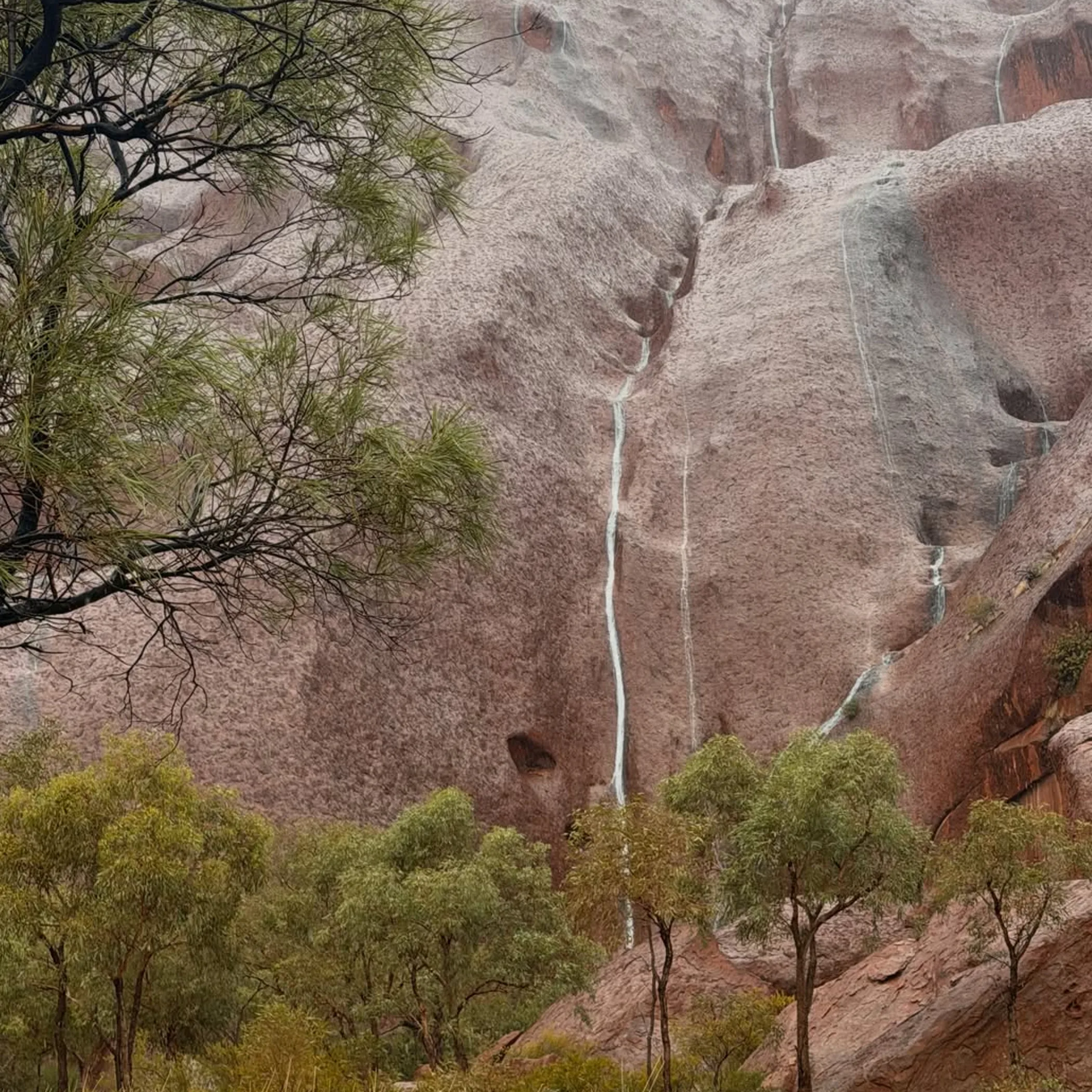 uluru rock with rain clouds