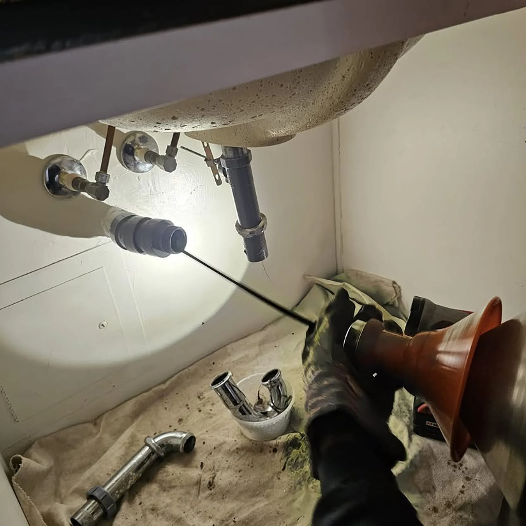 professional unclogging drain under sink